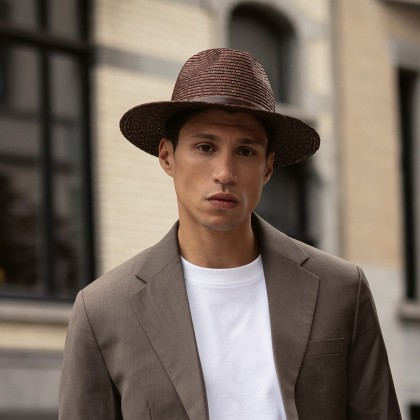 Large brim straw hat with belt and interior drawstring.